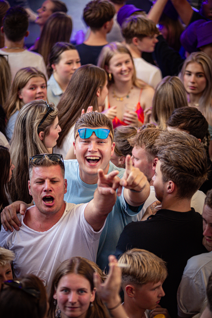 A group of young people enjoying a party, some with sunglasses on their heads.