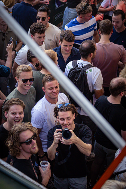 a group of young people at a music concert, with one man taking a photo.