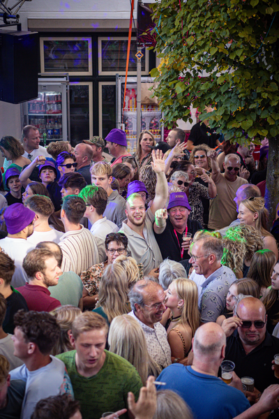 A group of people standing around, waving and smiling at the camera.