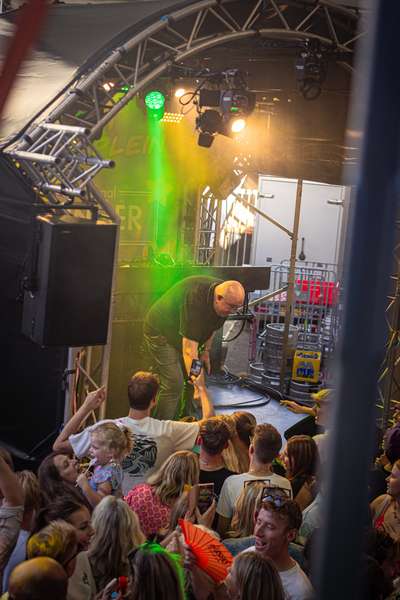 A man is on stage playing a guitar in front of a crowd.