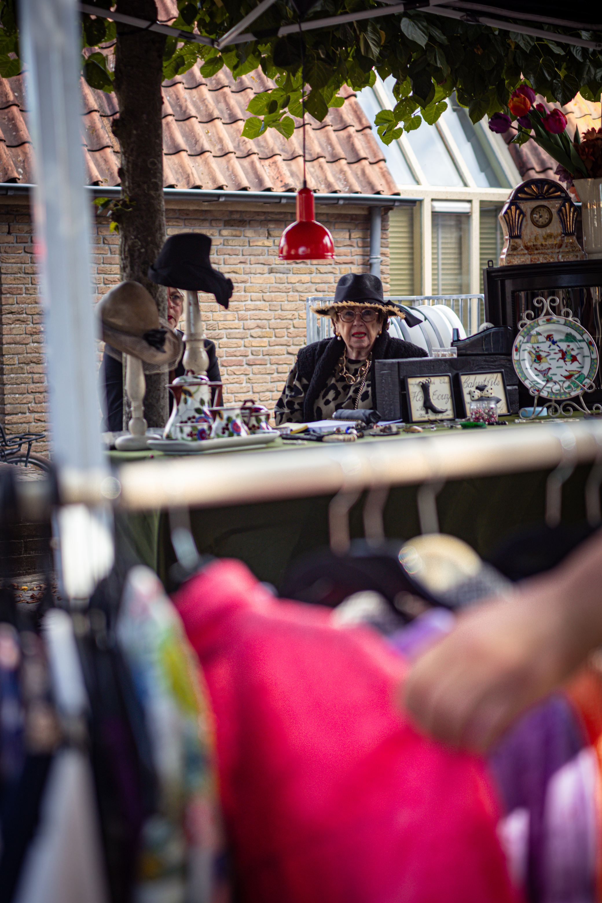 A woman sits at a table filled with various souvenirs and trinkets.