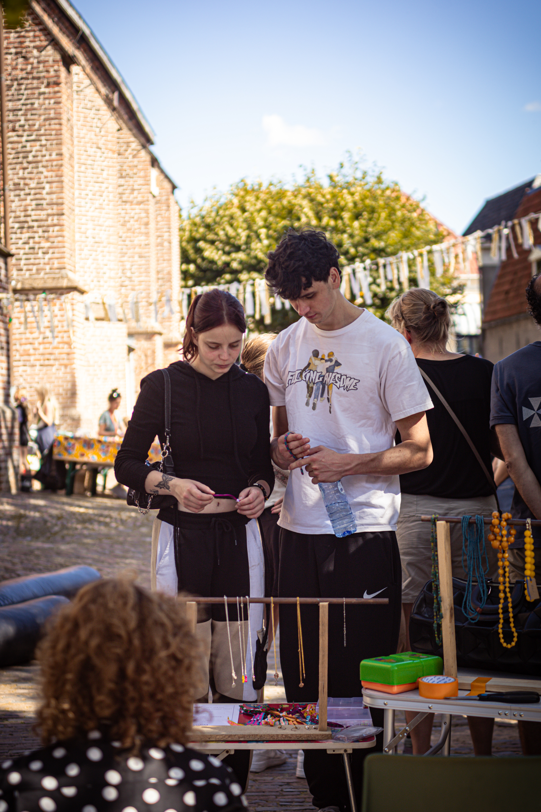 Two people standing next to a table with items on it.
