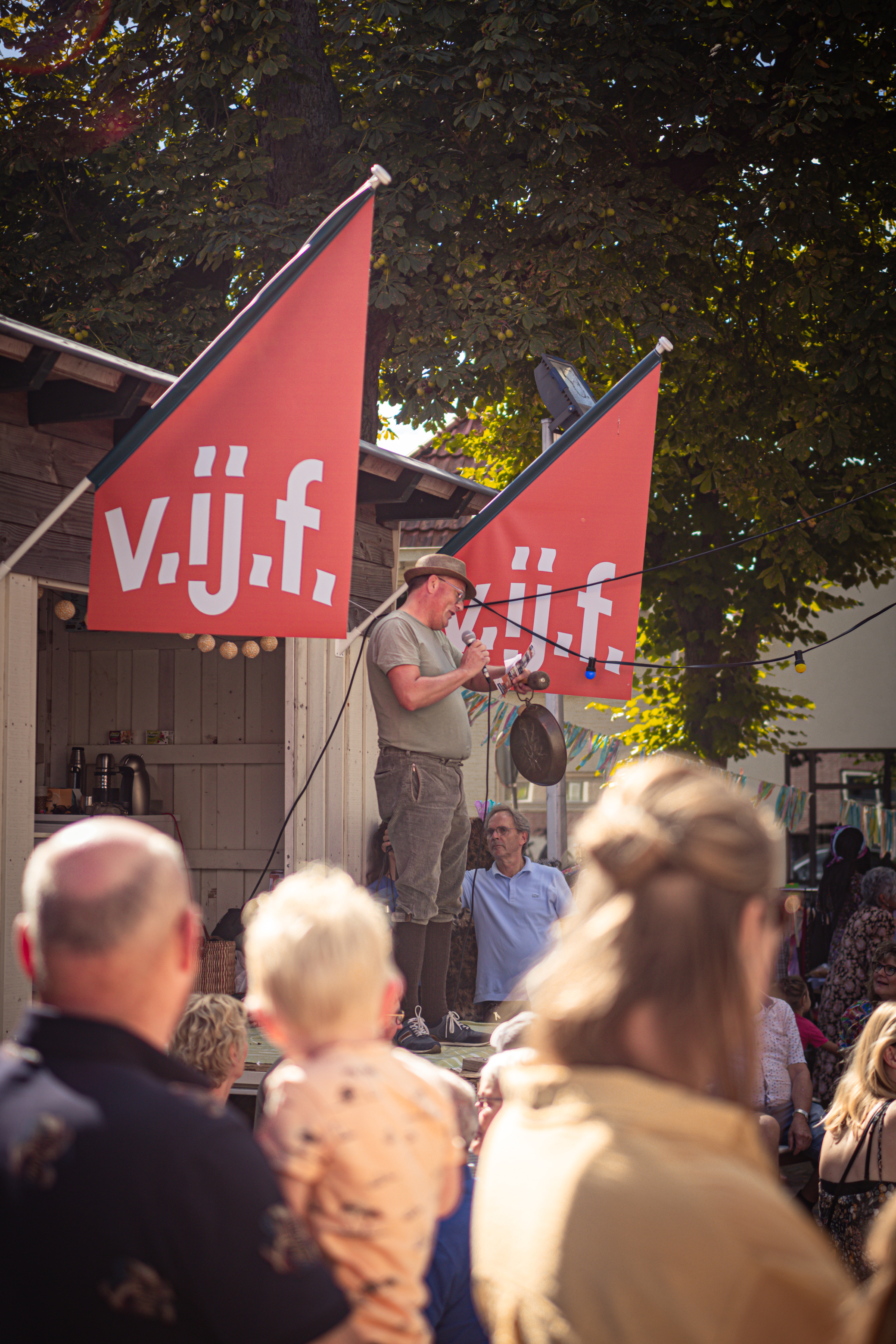 A group of people are gathered outside a venue for the Vijf.
