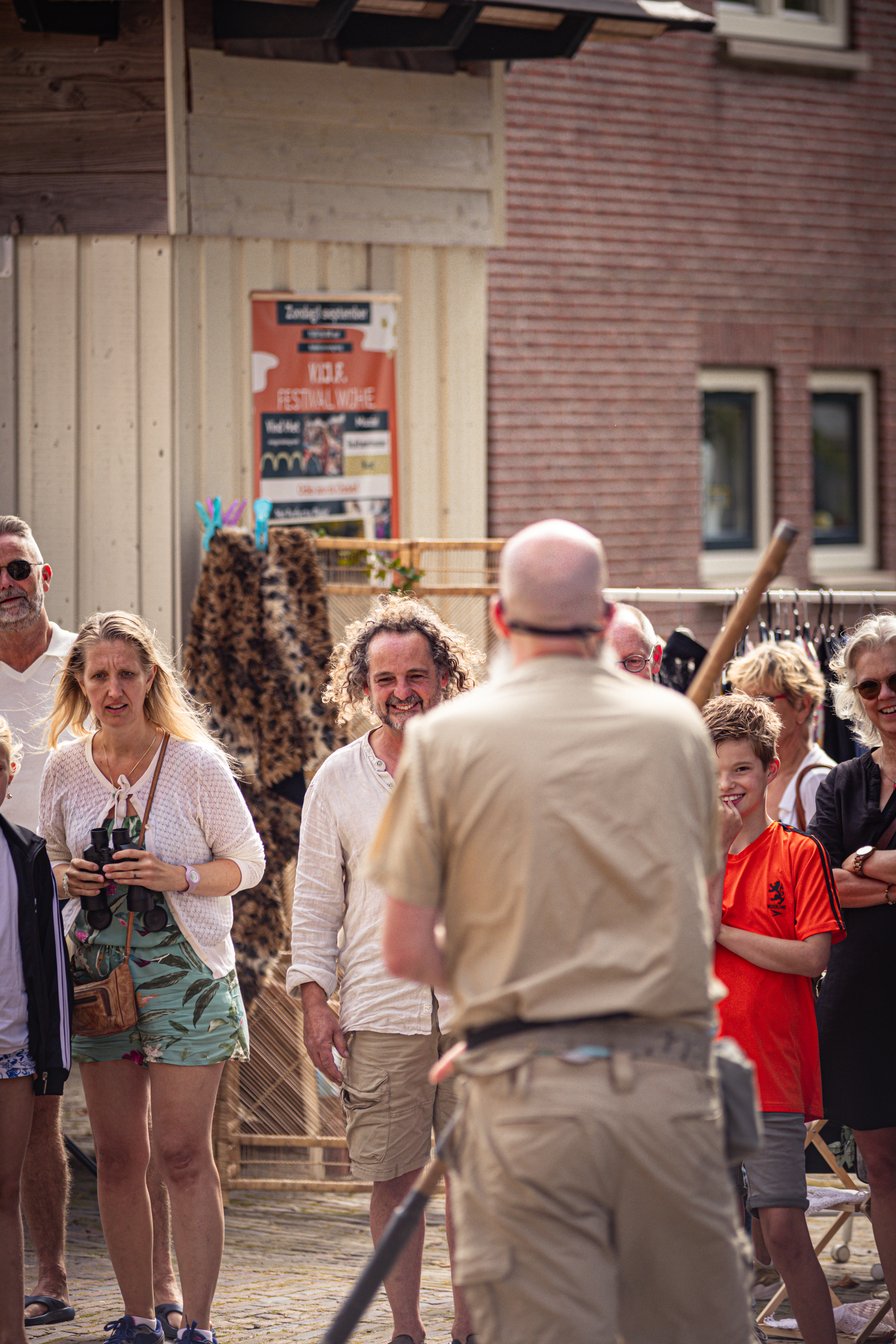 V.I.J. Festival - A man in a tan shirt stands next to a group of people at a festival.