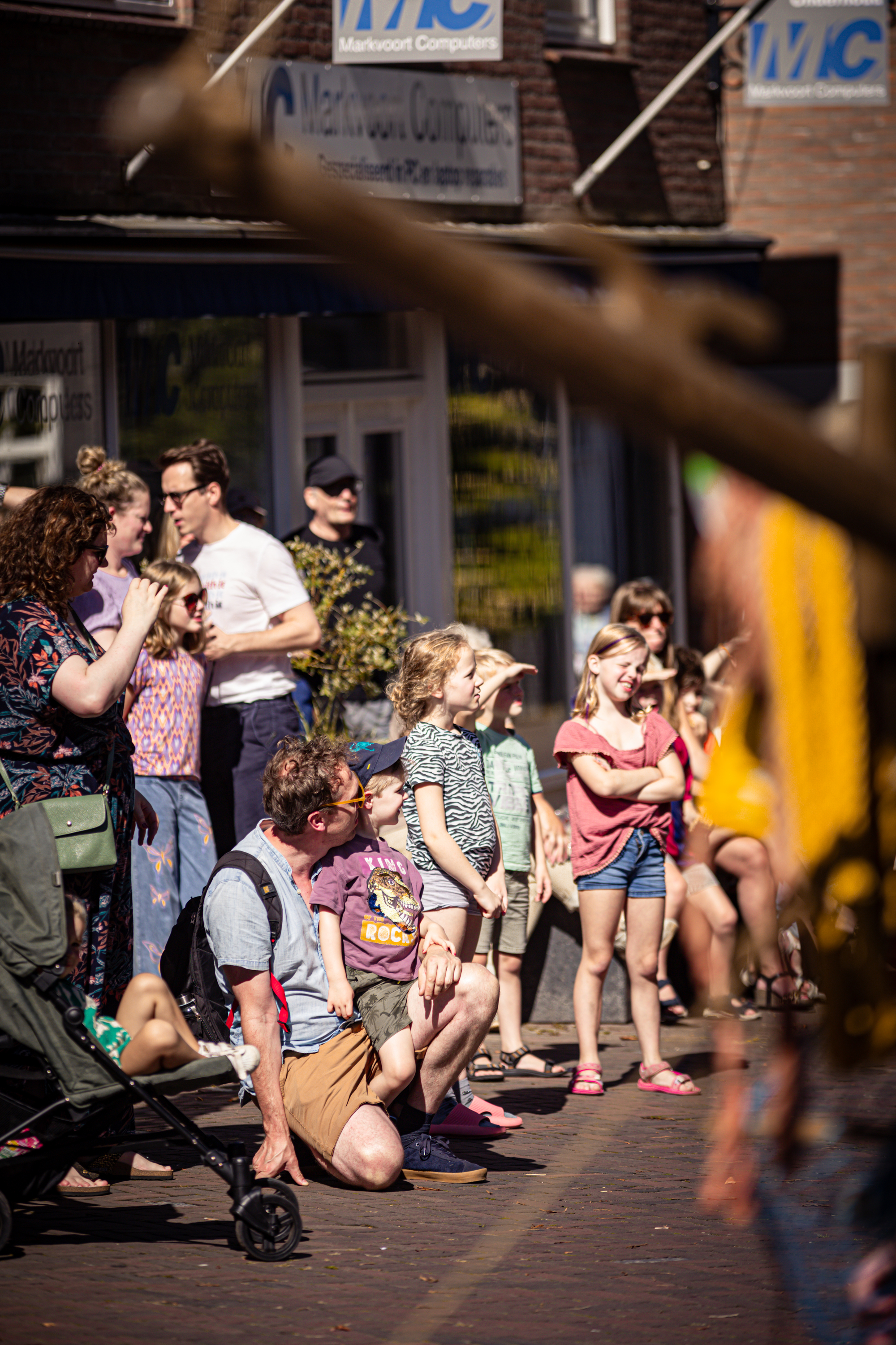 People standing on a street with the words MC and V.IJ.F. Festival in the background.