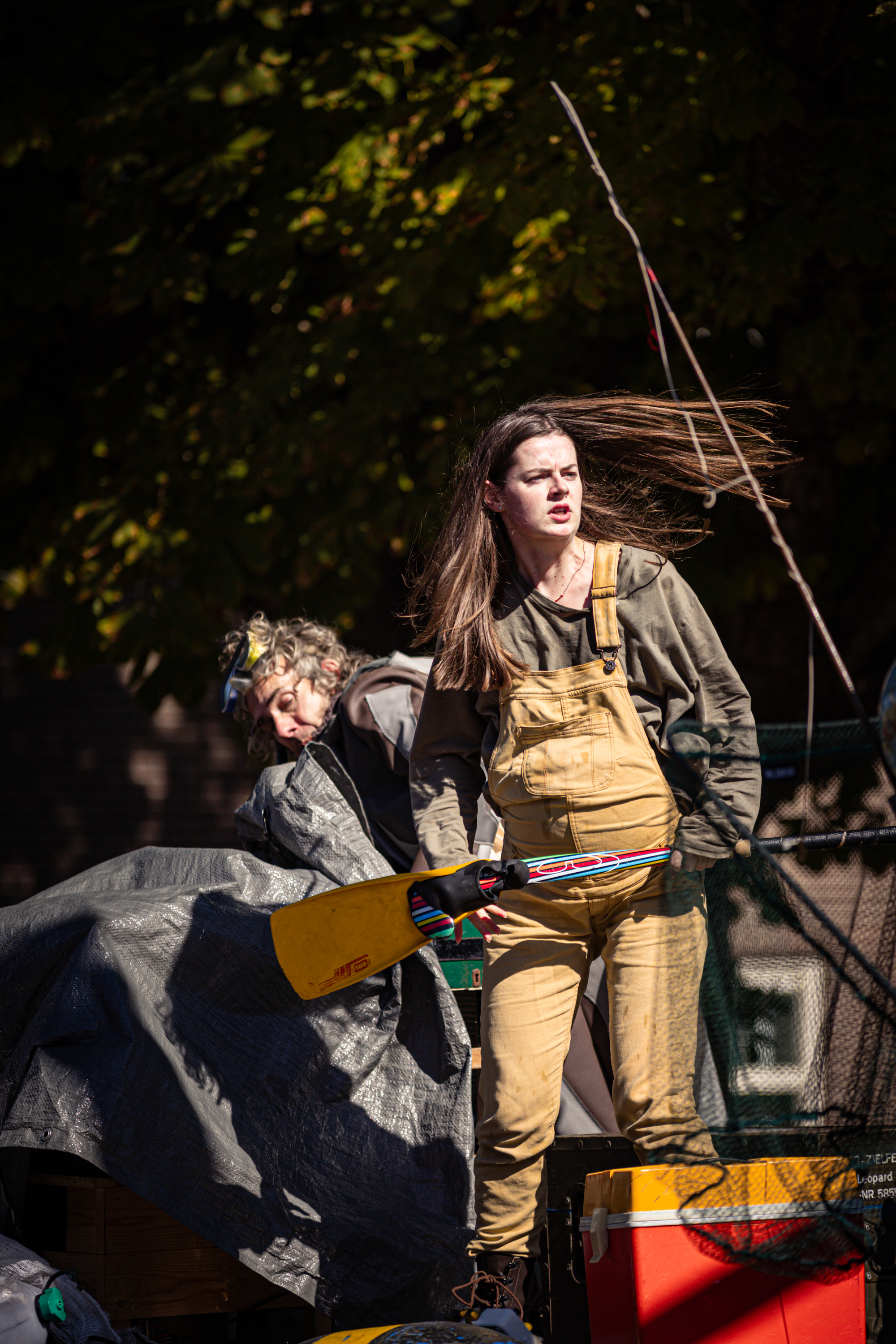 A woman is part of the V.IJ.F. Festival, standing on a platform and holding a prop.