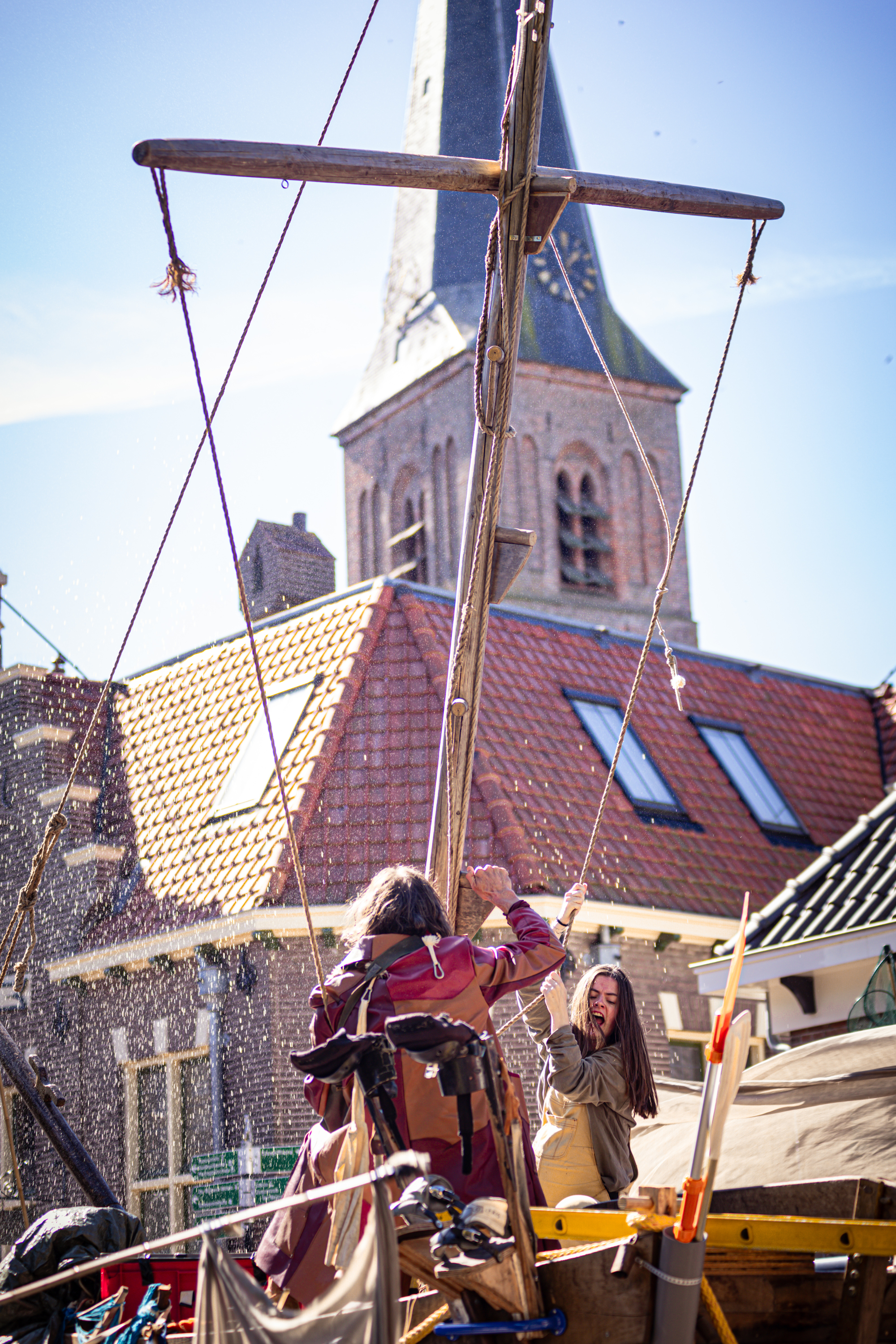 A woman in a red dress and another woman are standing on a small platform at the V.I.J.F. Festival.