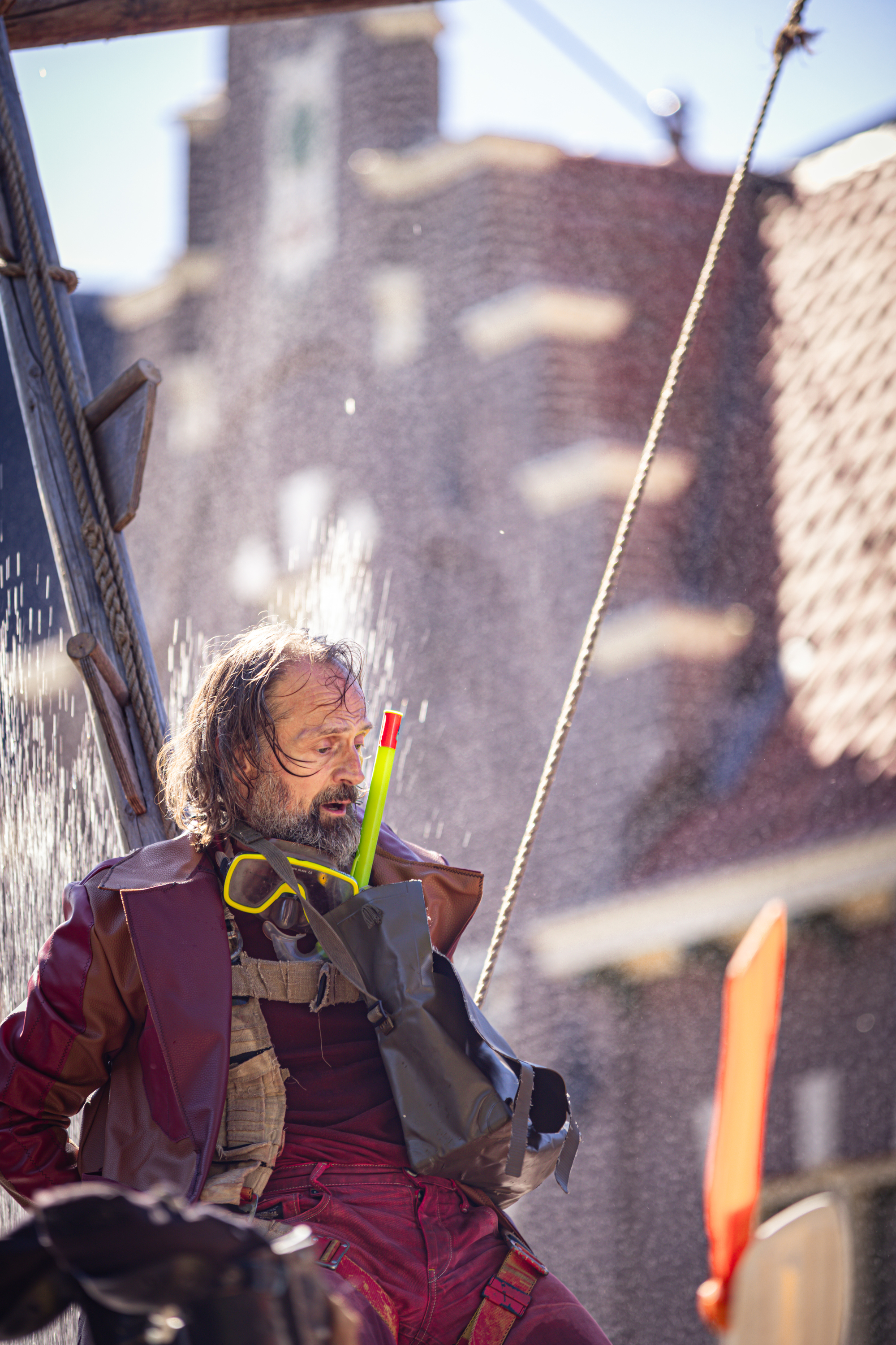 A man holding a yellow toothbrush and standing in front of the V.J.F. Festival sign.