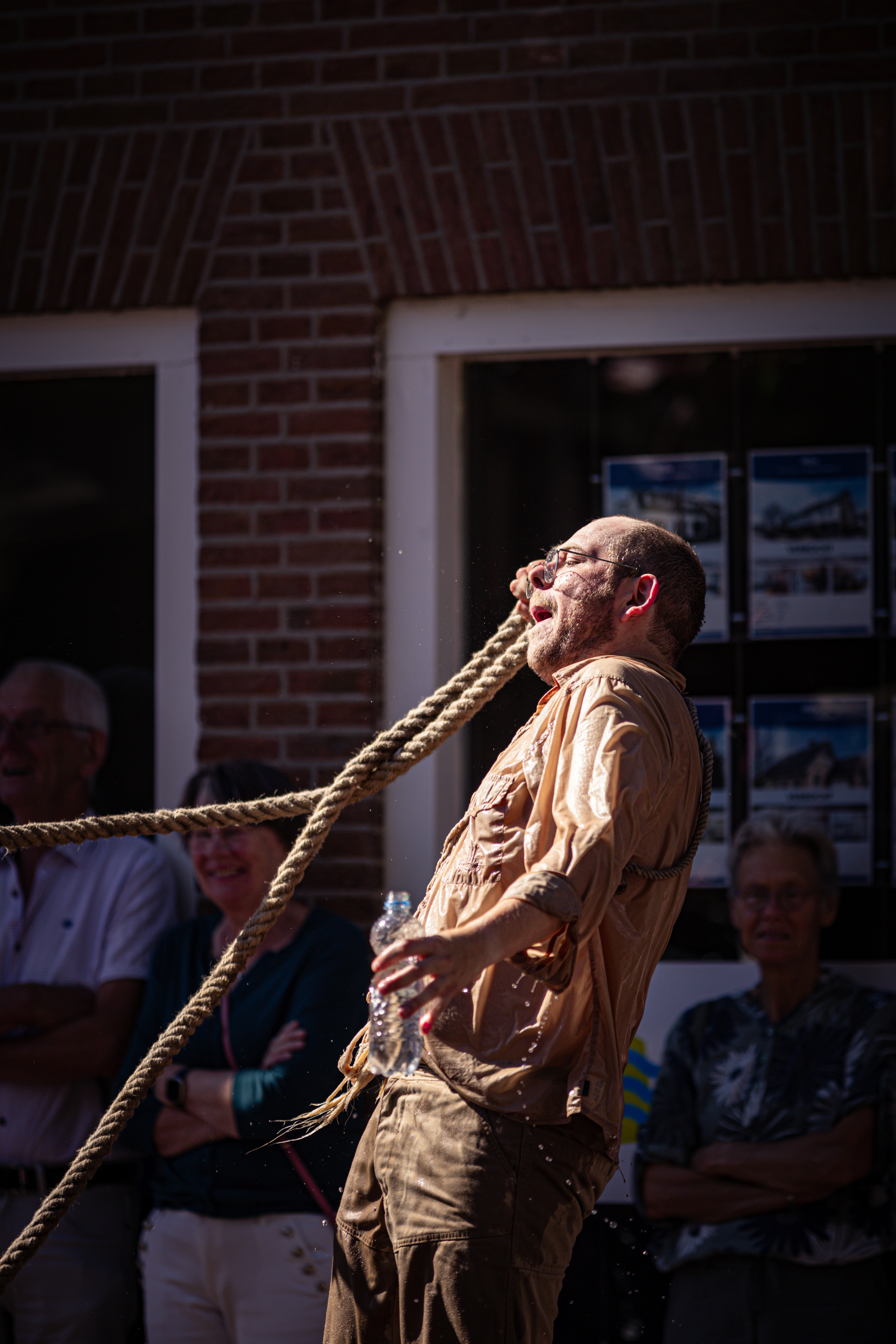 A man is seen dancing and he's wearing an orange shirt.
