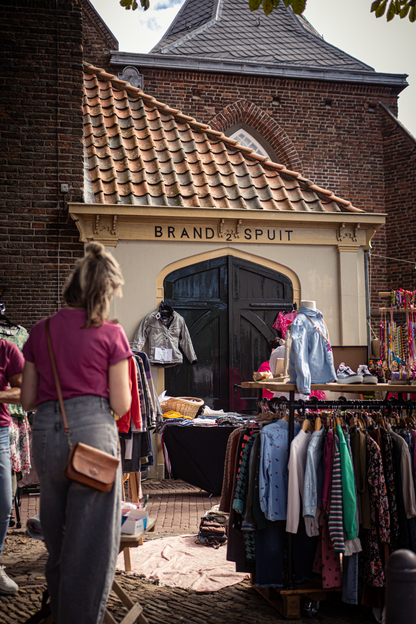 A woman in a pink shirt is shopping at the Brand Suit Store.