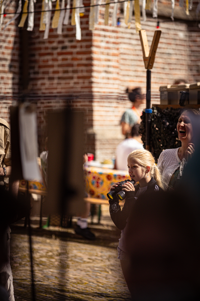 A woman is taking a picture of another woman who is laughing at the V. IJ.F. Festival.