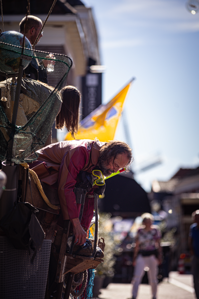 A man in a red shirt is taking pictures at an event.