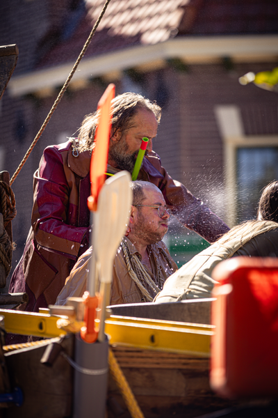 Two men in a boat, with one of them wearing glasses.