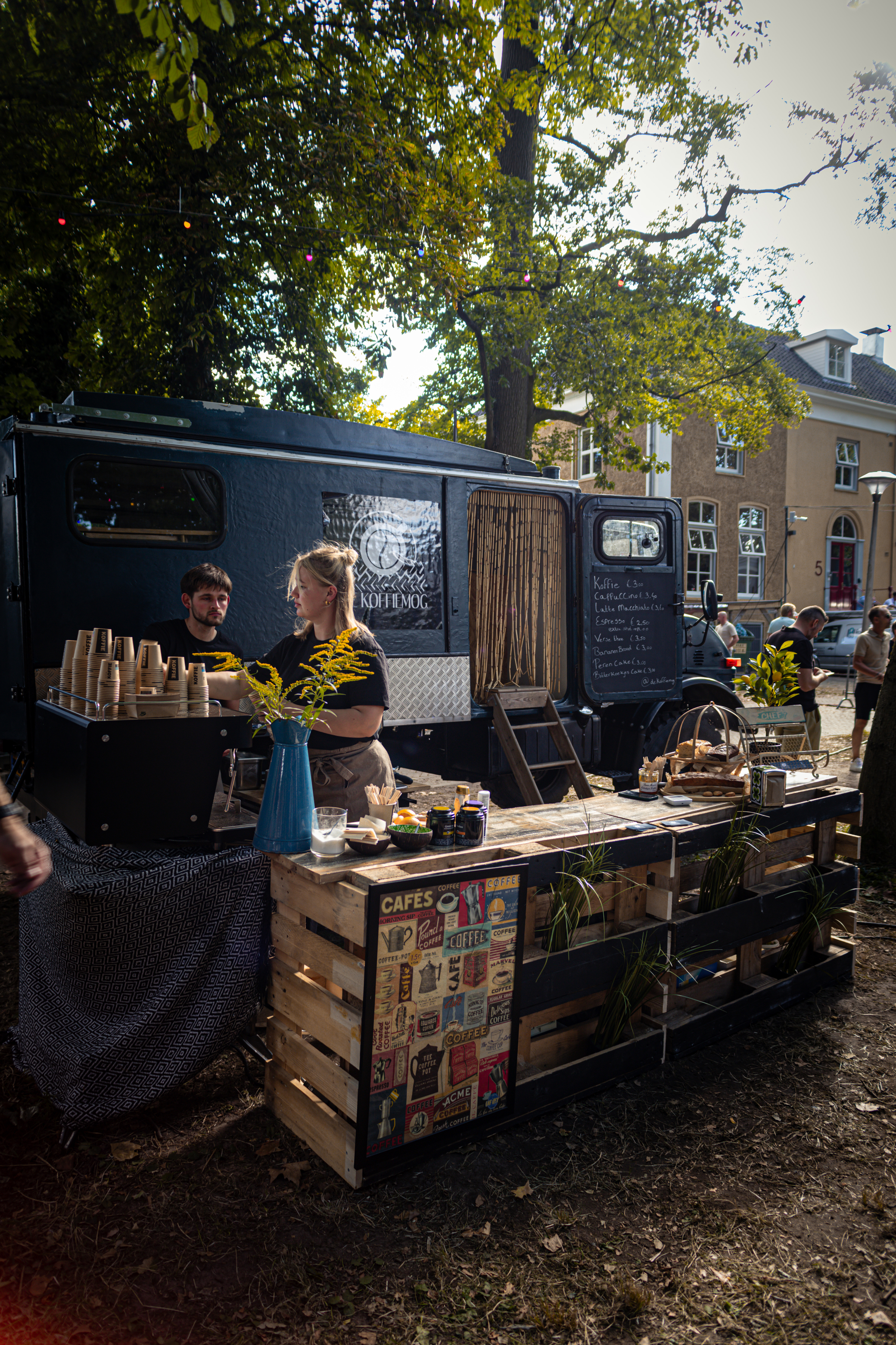 Two people standing at a booth with crates of beer.