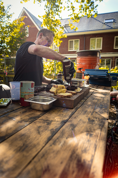 Een man in een park maakt sandwiches op een kieke.