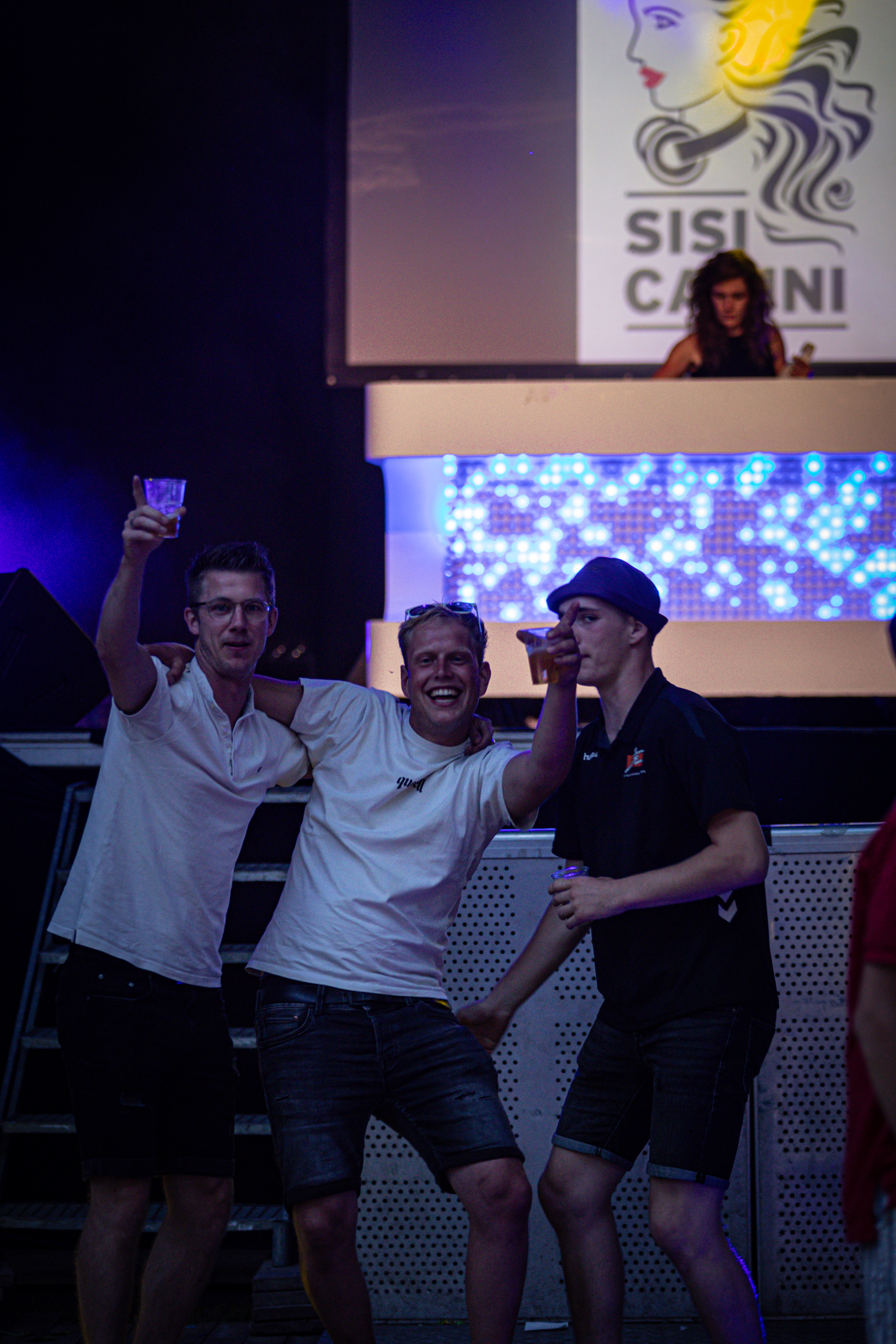 Several people posing for a photo with one of them holding up a drink at Sosi Carini